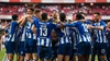 Die Mannschaft des FC Porto liegt sich im blau-weiß gestreiften Heimtrikot jubelnd in den Armen und feiert einen Torerfolg.